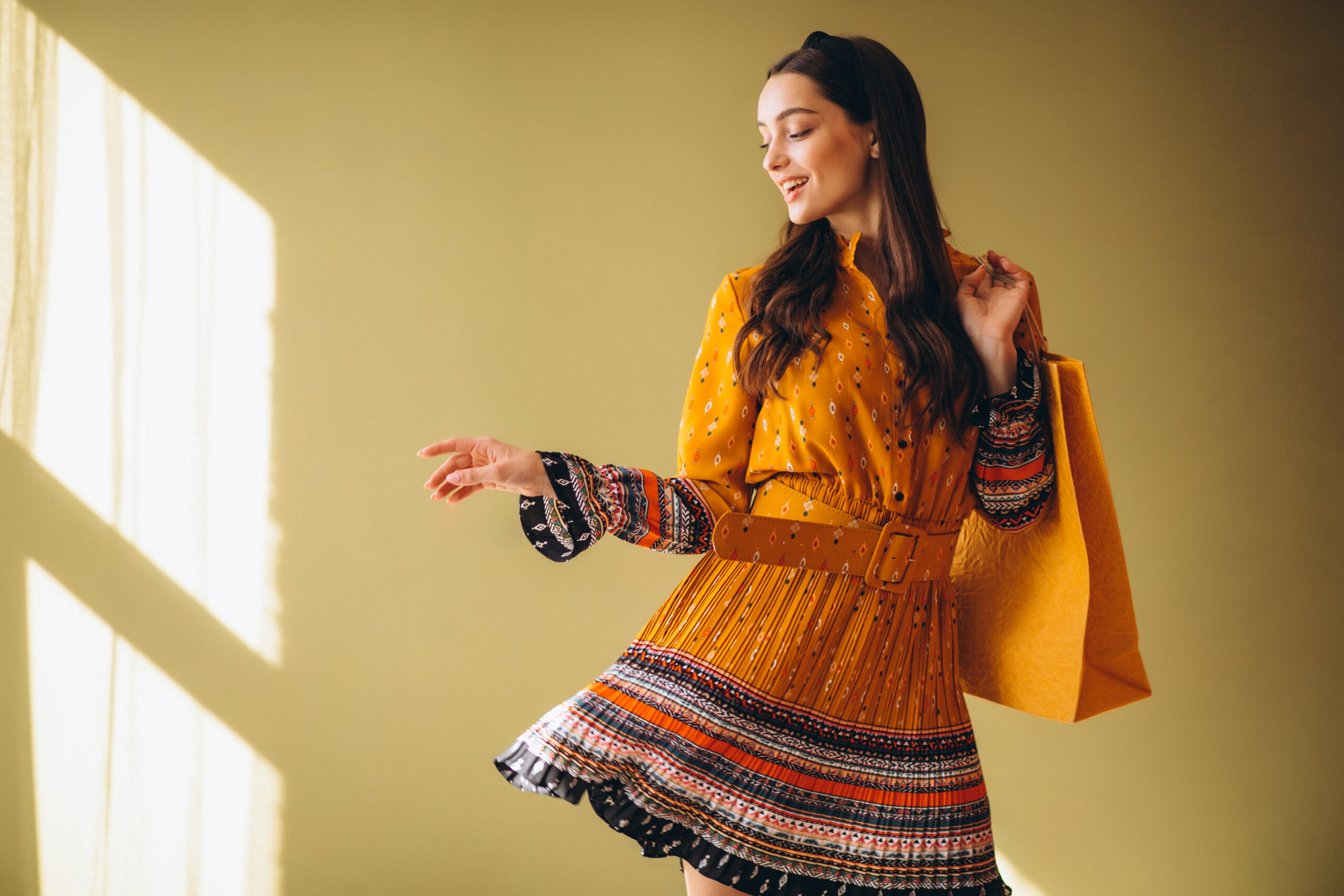 Young woman with shopping bags in a beautiful dress in studio